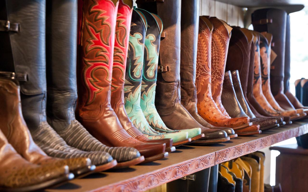 stivali da cowboy allineati su una mensola in un negozio (texas, stati uniti)