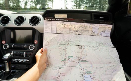 viaggiatore con una mappa dello yellowstone national park (wyoming, stati uniti)
