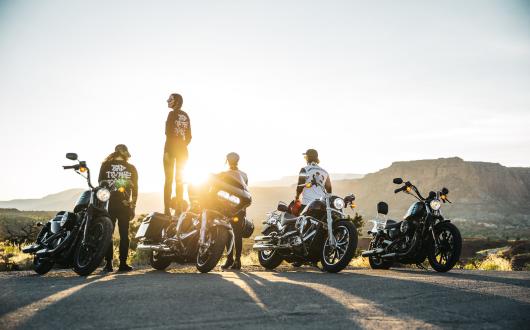 motociclisti ammirano il tramonto sulle moto parcheggiate