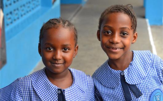 due bambine con vestiti scolastici (giamaica, caraibi)