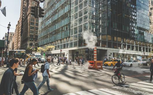 uomo in bicicletta e persone varie attraversano un incrocio a new york (new york, stati uniti)