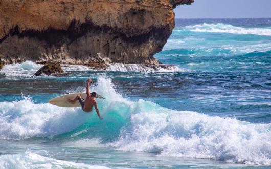 surfista tra le onde dell'oceano a kauai (hawaii, stati uniti)