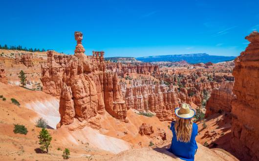 ragazza seduta tra gli hodoos al bryce canyon national park (utah, stati uniti)