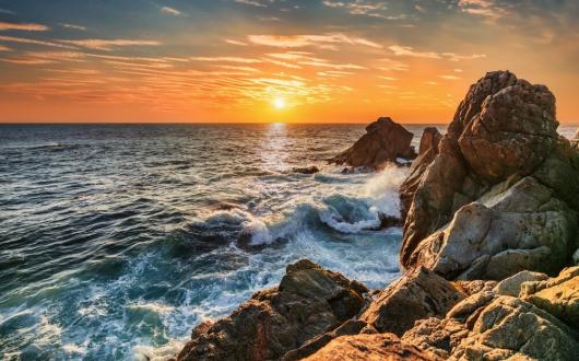 tramonto sull'oceano che si infrange sugli scogli a big sur (california, stati uniti)