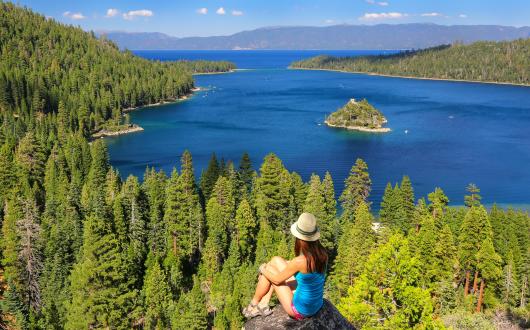 ragazza ammira il panorama di lake tahoe dall'alto (california, stati uniti)