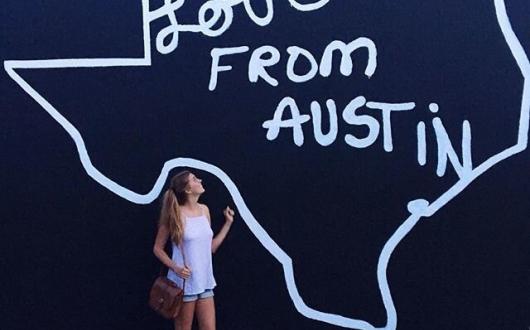 ragazza in posa davanti ad un graffito del texas ad austin (texas, stati uniti)