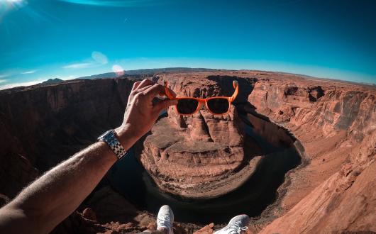 ragazzo mette gli occhiali da sole all'horseshoe bend (arizona, stati uniti)
