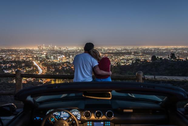 coppia abbracciata ammira le luci di los angeles di sera (california, stati uniti)