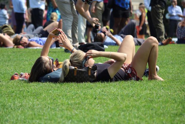 due ragazze distese sul prato osservano un'eclissi di sole (district of columbia, stati uniti)